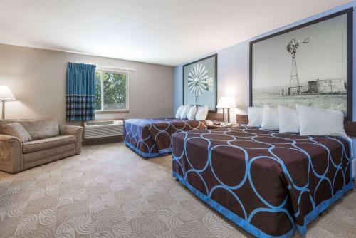 Habitación de hotel con 2 camas y sofá en Super 8 by Wyndham Beloit, en Beloit