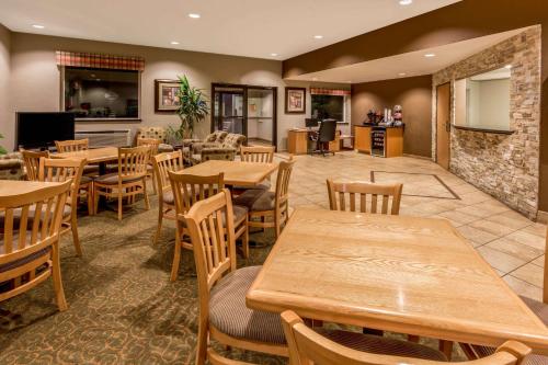a restaurant with wooden tables and wooden chairs at Super 8 by Wyndham Woodburn in Woodburn