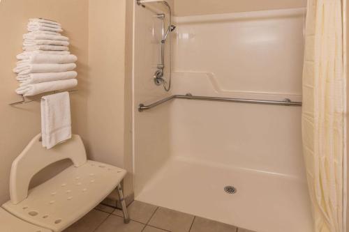 a bathroom with a shower and a toilet and a tub at Super 8 by Wyndham Woodburn in Woodburn