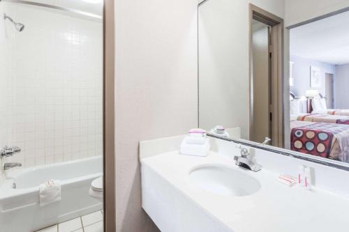 uma casa de banho com um lavatório e um espelho em Super 8 by Wyndham Greensboro em Greensboro