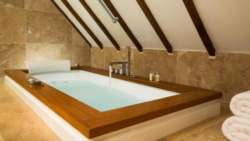 a bathroom with a bath tub with a sink at Priory Wareham in Wareham