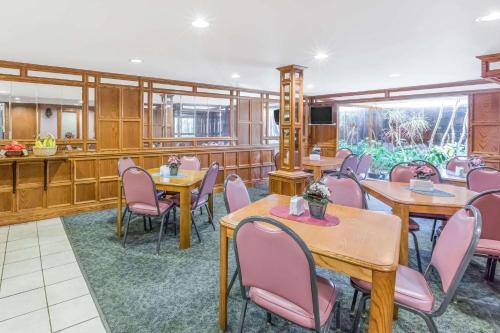 a restaurant with wooden tables and pink chairs at Knights Inn & Suites South Sioux City in South Sioux City