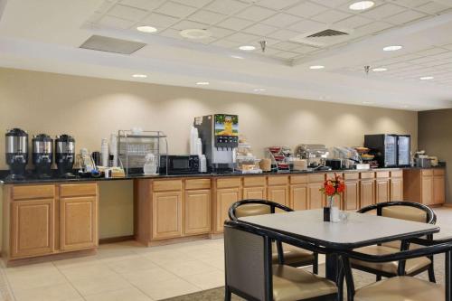 a coffee shop with a table and a counter at Wingate by Wyndham Pueblo in Pueblo
