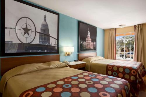 a hotel room with two beds and a window at Super 8 by Wyndham Austin Downtown/Capitol Area in Austin