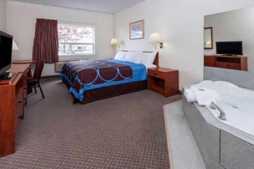 a hotel room with a bed and a bath tub at Super 8 by Wyndham Edmonton/West in Edmonton