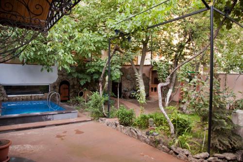 un jardín con piscina y árboles en Hin Yerevantsi Hotel en Ereván