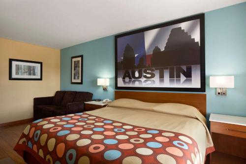 a hotel room with a bed and a large screen at Super 8 by Wyndham Austin Downtown/Capitol Area in Austin