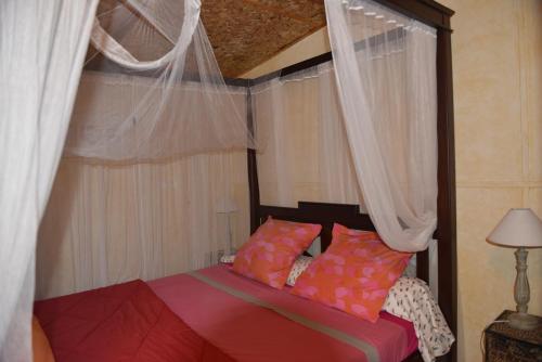a bedroom with a bed with curtains and a canopy at Villa Hélèna Chalets in Sainte-Marie