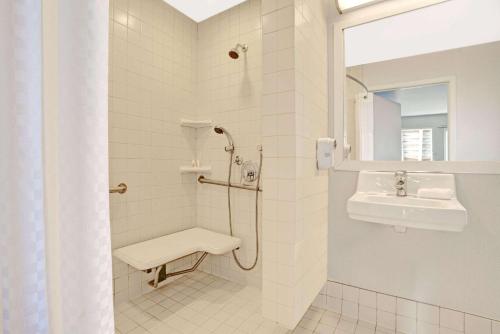 a white bathroom with a sink and a shower at Travelodge by Wyndham Mill Valley/Sausalito in Mill Valley