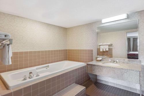 ein Badezimmer mit einer Badewanne und einem Waschbecken in der Unterkunft Travelodge by Wyndham Winchester in Winchester