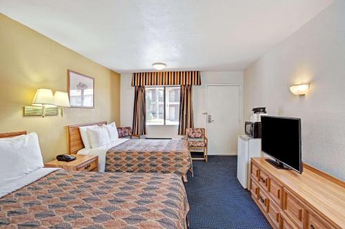 a hotel room with two beds and a flat screen tv at Travelodge by Wyndham Banning Casino and Outlet Mall in Banning