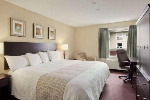 Habitación de hotel con cama grande y ventana en Travelodge Hotel by Wyndham Sudbury, en Sudbury