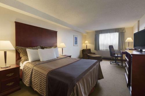a hotel room with a bed and a television at Travelodge Hotel by Wyndham Vancouver Airport in Richmond