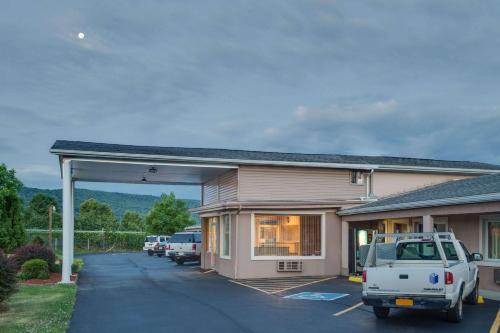 a building with a car parked in a parking lot at Travel Inn in Horseheads