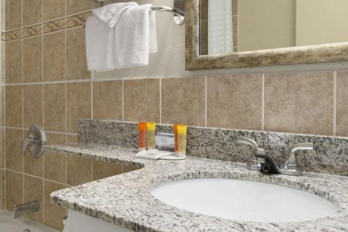 a bathroom with a sink and a mirror at Travelodge by Wyndham Edmonton East in Edmonton