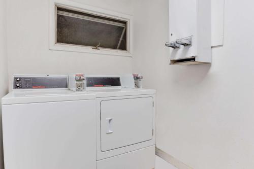 a white kitchen with a dishwasher and a window at Travel Inn in Horseheads