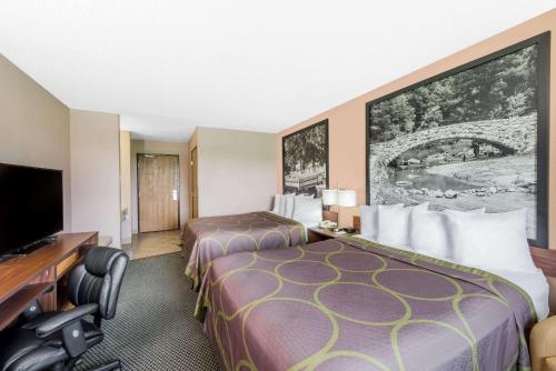 a hotel room with two beds and a flat screen tv at Super 8 by Wyndham Winfield-Quail Ridge Area in Winfield