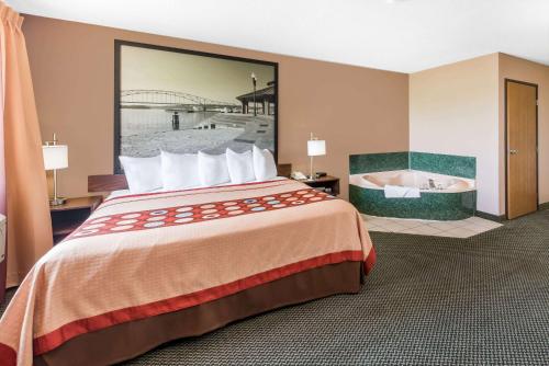 a hotel room with a bed and a bath tub at Super 8 by Wyndham Winfield-Quail Ridge Area in Winfield