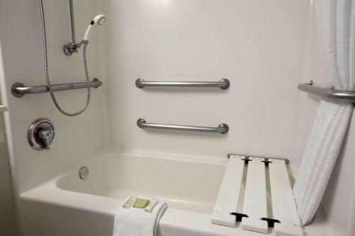 y baño con ducha y bañera blanca. en Super 8 by Wyndham South Padre Island en South Padre Island