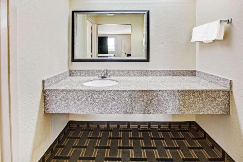 a bathroom with a sink and a mirror at Super 8 by Wyndham Baytown I-10 in Baytown