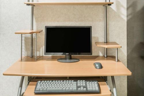 a computer monitor and a keyboard and mouse on a desk at Super 8 by Wyndham Maumee Perrysburg Toledo Area in Maumee