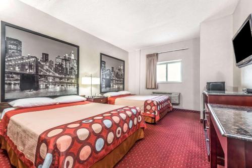 a hotel room with two beds and a flat screen tv at Super 8 by Wyndham North Bergen NJ/NYC Area in North Bergen