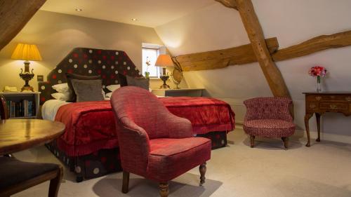 a bedroom with a red bed and a chair at Priory Wareham in Wareham