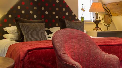 a bedroom with a bed with a red couch at Priory Wareham in Wareham