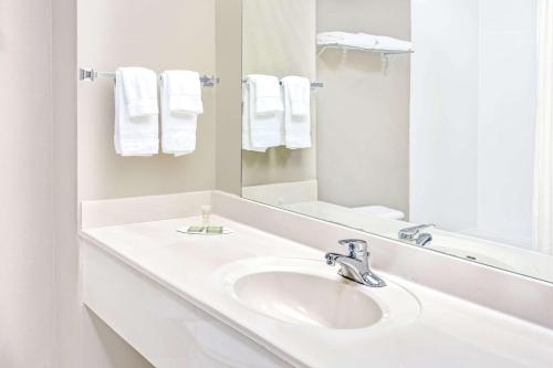 a white bathroom with a sink and a mirror at Super 8 by Wyndham Dawsonville in Dawsonville