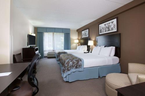 una camera d'albergo con un grande letto e una scrivania di Wingate by Wyndham Garner/Raleigh South a Garner