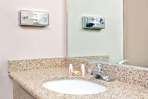La salle de bains est pourvue d'un lavabo et d'un miroir. dans l'établissement Super 8 by Wyndham Upland Ontario CA, à Upland