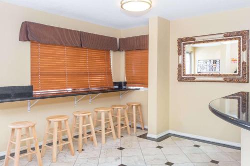 een bar met krukken in een kamer met een spiegel bij Super 8 by Wyndham Azusa in Azusa