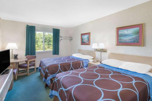 a hotel room with two beds and a desk at Super 8 by Wyndham Canandaigua in Canandaigua