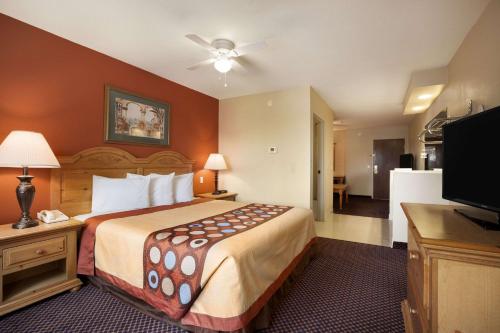 a hotel room with a bed and a flat screen tv at Super 8 by Wyndham Marana/Tucson Area in Tucson