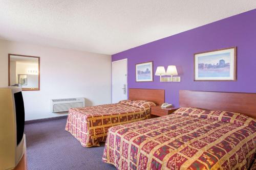 a hotel room with two beds and purple walls at Knights Inn Phoenix at N Black Canyon Hwy in Phoenix