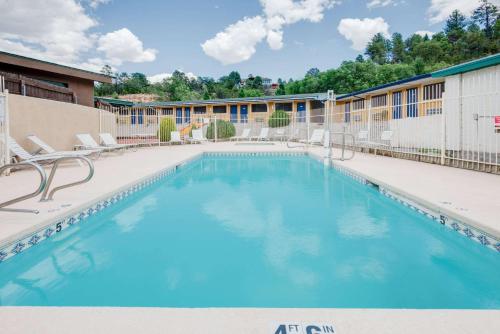 a large swimming pool with chairs and a building at Travelodge by Wyndham Ruidoso in Ruidoso