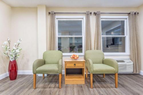 two chairs and a table in a room with a window at Super 8 by Wyndham Manning in Manning