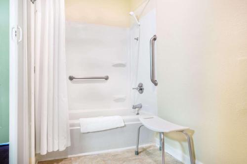 a bathroom with a shower with a stool in it at Super 8 by Wyndham Manning in Manning