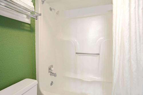 a bathroom with a white shower curtain and a toilet at Super 8 by Wyndham Denver Stapleton in Denver