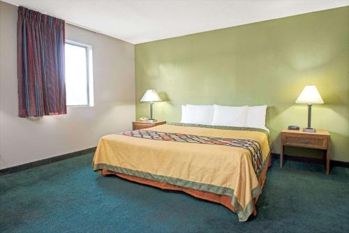 a hotel room with a bed and a window at Super 8 by Wyndham Eureka/Six Flags Nearby in Eureka