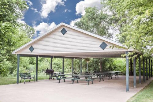 a pavilion with picnic tables and benches in a park at Super 8 by Wyndham Three Rivers in Three Rivers