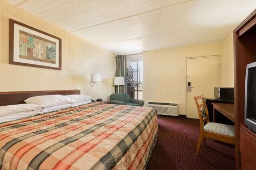 ブレナムにあるKnights Inn Brenhamのベッドと机とテレビがあるホテルの部屋