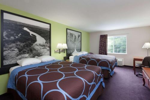 a hotel room with two beds and a window at Super 8 by Wyndham Huntsville in Huntsville