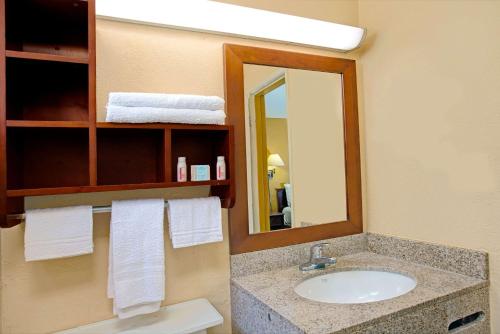 a bathroom with a sink and a mirror at Travelodge by Wyndham Fort Lauderdale in Fort Lauderdale