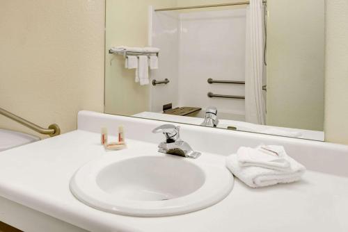 uma casa de banho com um lavatório branco e um espelho. em Super 8 by Wyndham De Soto em De Soto