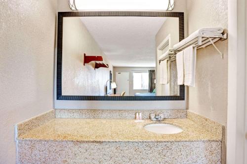 a bathroom with a sink and a large mirror at Super 8 by Wyndham Fredericksburg in Fredericksburg