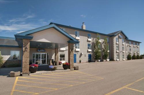 an empty parking lot in front of a hotel at Travelodge by Wyndham Stony Plain in Stony Plain