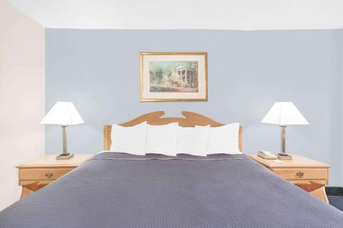 a bedroom with a blue bed with two lamps at Howard Johnson by Wyndham Staunton in Staunton