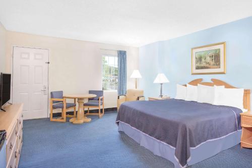 Howard Johnson by Wyndham Staunton في ستونتون: غرفة فندقية بسرير وطاولة وكراسي