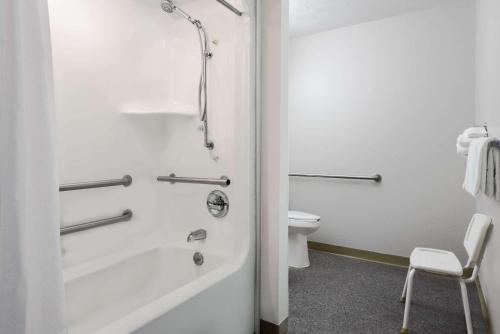 a bathroom with a bath tub and a toilet at Microtel Inn & Suites by Wyndham London in London